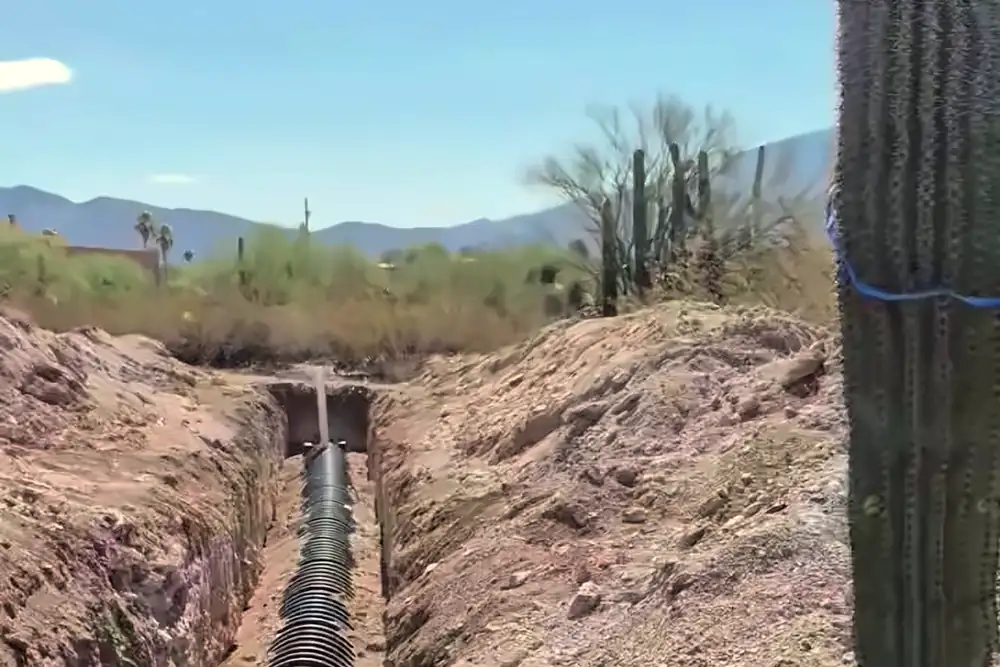 Leach field trench with perforated pipe, saguaro at the edge